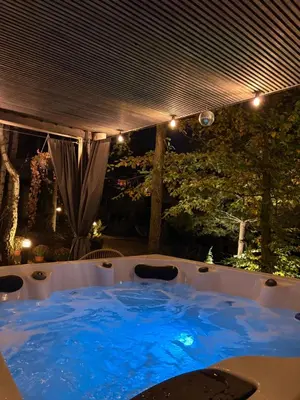 a hot tub with blue water in a backyard at Mucharskie Stodoły Stodoła II - Garden Spa in Jaszczurowa