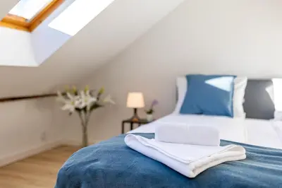 a bed with blue and white pillows and a lamp at Apartment with Entresol Old Town Krakow in Kraków