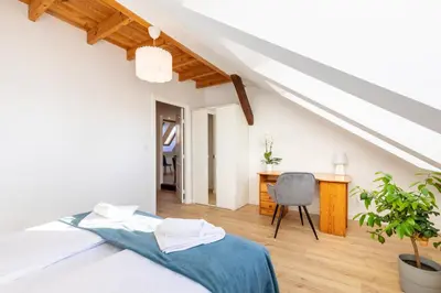 a vase of white flowers in a bedroom with a bed at Apartment with Entresol Old Town Krakow in Kraków