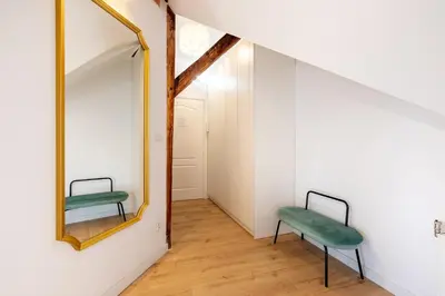 a room with a mirror and a green chair at Apartment with Entresol Old Town Krakow in Kraków