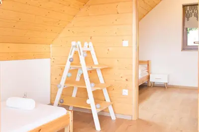 a bedroom in a wooden cabin with a bed at Domki w Kasinie in Kasina Wielka