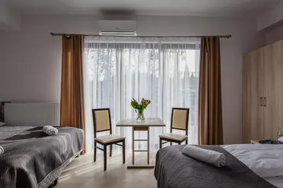 a bedroom with a table and chairs and a window at Agroturystyka Premium Cracovia Arabians - Ojcowski Park Narodowy in Maszyce