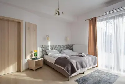 a bedroom with a large bed and a large window at Agroturystyka Premium Cracovia Arabians - Ojcowski Park Narodowy in Maszyce