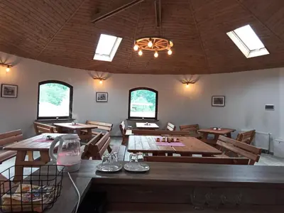 a dining room with wooden tables and chairs and windows at Agroturystyka Premium Cracovia Arabians - Ojcowski Park Narodowy in Maszyce