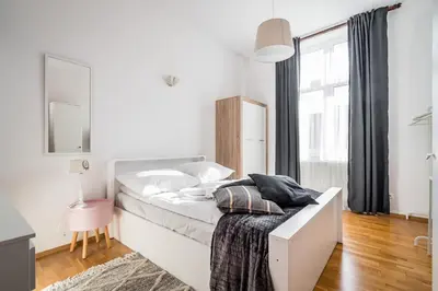 a white bedroom with a bed and a window at Apartment Krakowska City Center WAWELOFTS in Kraków