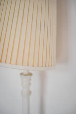 a white lamp with a white shade on a table at Apartment Krakowska City Center WAWELOFTS in Kraków