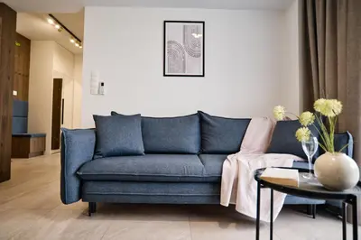 a living room with a blue couch and a table at Apartament Bliss 16 Zator by Housine in Zator