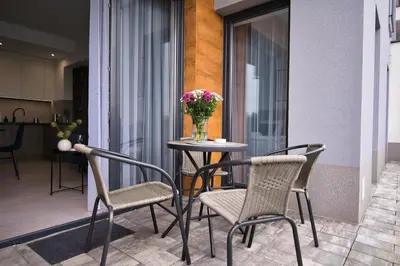 a table and chairs on a balcony with a vase of flowers at Apartament Bliss 16 Zator by Housine in Zator
