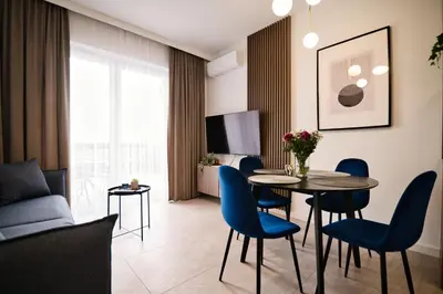 a living room with a table and blue chairs at Apartament Bliss 16 Zator by Housine in Zator