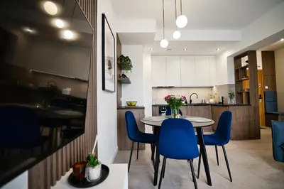 a kitchen and dining room with a table and blue chairs at Apartament Bliss 16 Zator by Housine in Zator