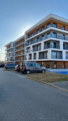 a parking lot with cars parked in front of a building at Apartament Bliss 16 Zator by Housine in Zator