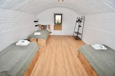 two beds in a room with a wooden floor at Kraków Family Nest in Kraków