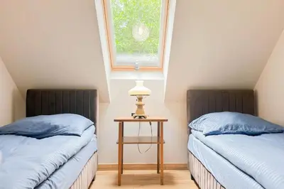 two beds in a room with a table and a window at Apartament Ptasi Śpiew 2 in Rabka