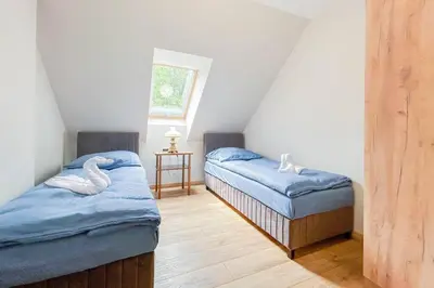 a attic room with two beds and a swan mattress at Apartament Ptasi Śpiew 2 in Rabka