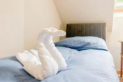 a bed with two white towels laying on it at Apartament Ptasi Śpiew 2 in Rabka