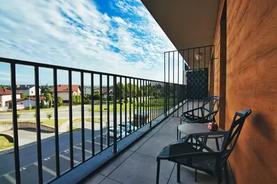 a balcony with two chairs and a table with a view at Apartament Lider 41 by Housine in Zator