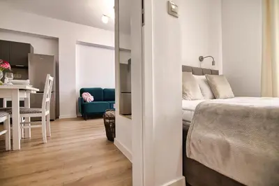 a bedroom with a bed and a dining room with a table at Apartament Lider 41 by Housine in Zator