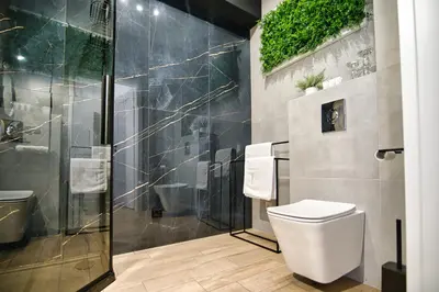 a bathroom with a toilet and a glass shower at Apartament Lider 41 by Housine in Zator