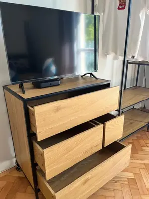 a flat screen tv on a wooden entertainment center at Apartament Globtroter in Kraków