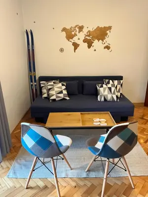 a living room with a couch and a table and chairs at Apartament Globtroter in Kraków