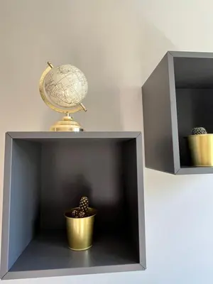 a gray shelf with a globe and a plant at Apartament Globtroter in Kraków
