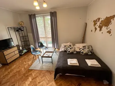 a bedroom with a large bed and a table and chair at Apartament Globtroter in Kraków