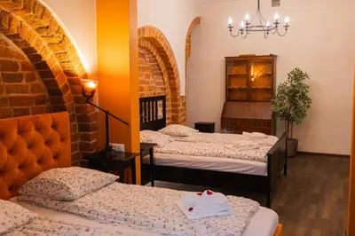 a room with three beds and a chandelier at Lux apartmenty - Old City Kraków in Kraków