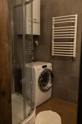 a washing machine in a bathroom with a shower at Lux apartmenty - Old City Kraków in Kraków