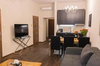a living room with a dining room table and a kitchen at Lux apartmenty - Old City Kraków in Kraków