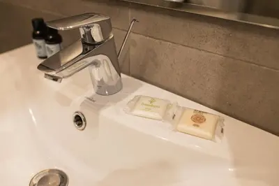 a bathroom sink with a faucet and two soap dishes at Lux apartmenty - Old City Kraków in Kraków