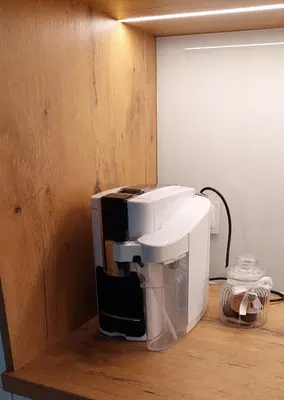 a white coffee maker sitting on a wooden shelf at Apartament Aktorów Bronowice in Kraków