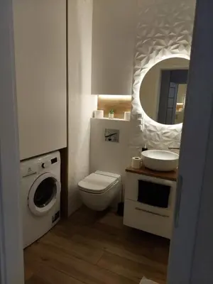 a bathroom with a toilet and a sink and a mirror at Apartament Aktorów Bronowice in Kraków