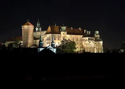 a large castle is lit up at night at Apartament Piccolo in Kraków