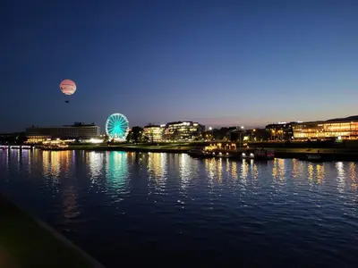 a city lit up at night with a ferris wheel at Apartament Piccolo in Kraków