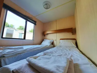 two beds in a small room with a window at Pensjonat Łysa Góra in Zator