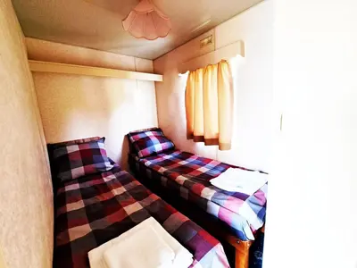 a small room with two beds and a window at Pensjonat Łysa Góra in Zator