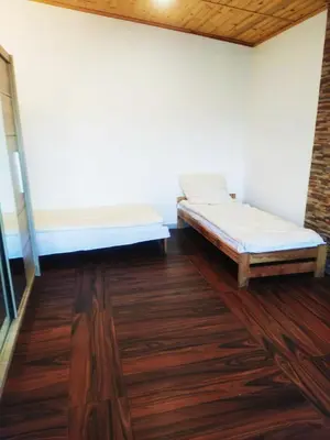 two beds in a room with wood floors at Pensjonat Łysa Góra in Zator
