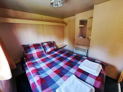 a bed in a room with a checkered blanket at Pensjonat Łysa Góra in Zator