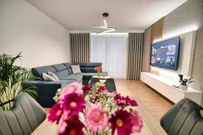 a living room with a couch and a table with flowers at Golden 42 in Zator