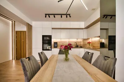 a dining room table with chairs and a vase of flowers at Golden 42 in Zator