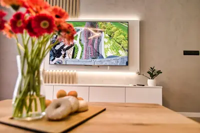 a table with a vase of flowers and a tv screen at Golden 42 in Zator