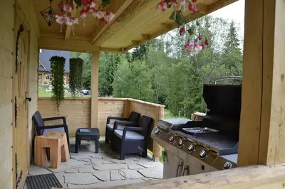 a patio with an outdoor kitchen with a stove at Domek w górach SmoLenisko in Nowy Targ