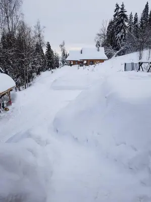 a road covered in snow in front of a house at Domek w górach SmoLenisko in Nowy Targ