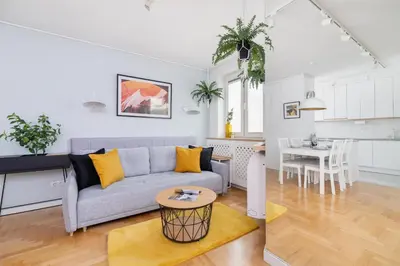 a living room and kitchen with a couch and a table at Cozy Apartment Bartla 19 by Noclegi Renters in Kraków