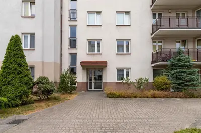 an apartment building with a driveway in front of it at Cozy Apartment Bartla 19 by Noclegi Renters in Kraków