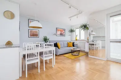 a kitchen and living room with a table and a couch at Cozy Apartment Bartla 19 by Noclegi Renters in Kraków