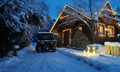 a jeep parked in front of a house in the snow at Alpakowy raj in Nowy Targ