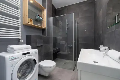 a bathroom with a washer and a toilet and a sink at Sunny Studio Mostowa Krakow Kazimierz by Nolegi Renters in Kraków