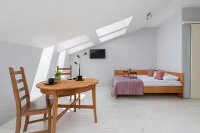 a bedroom with a bed and a table with a chair at Sunny Studio Mostowa Krakow Kazimierz by Nolegi Renters in Kraków