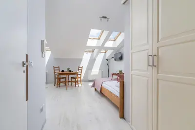 a bedroom with a bed and a table with chairs at Sunny Studio Mostowa Krakow Kazimierz by Nolegi Renters in Kraków